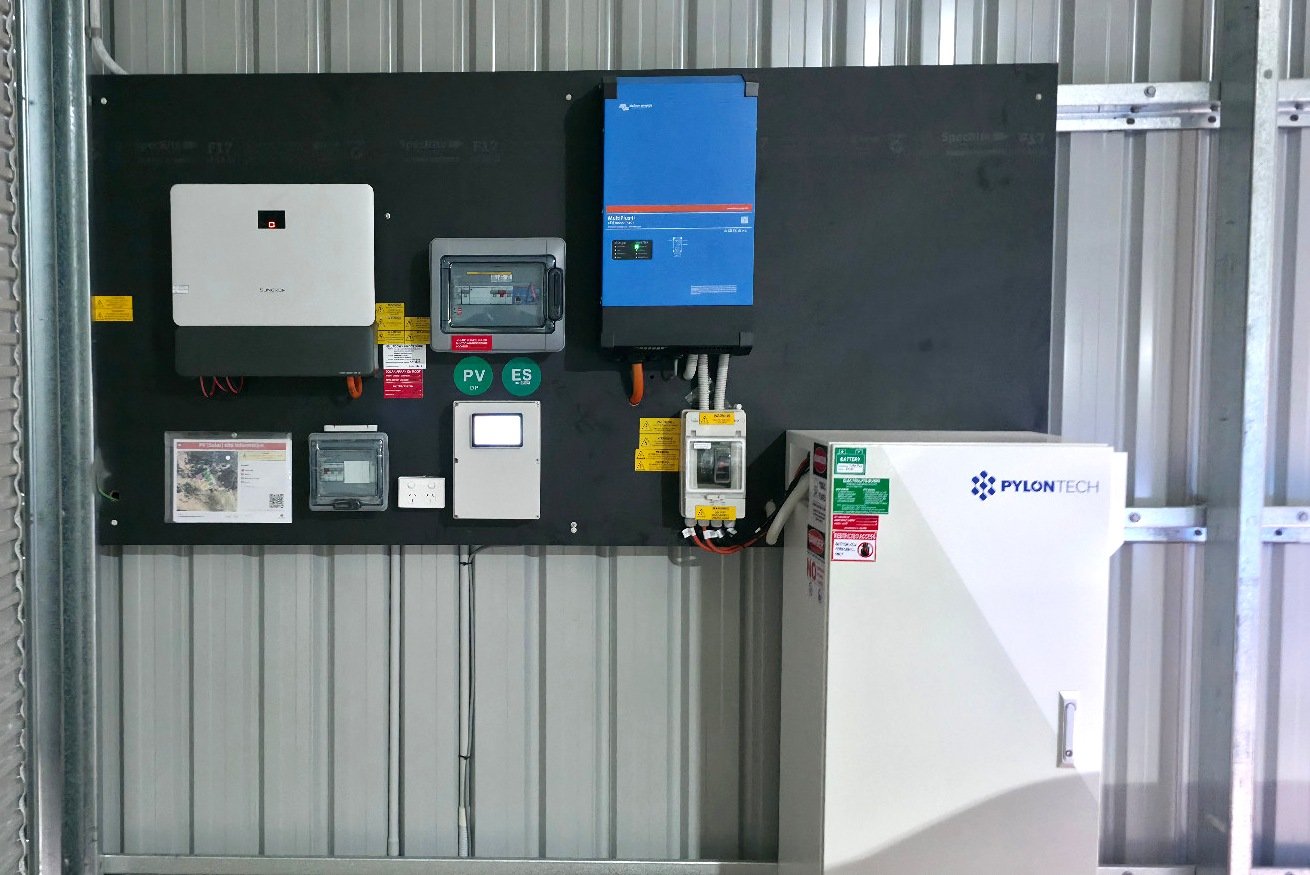 Off-grid solar and battery installation with wall-mounted inverters and a Pylontech battery cabinet